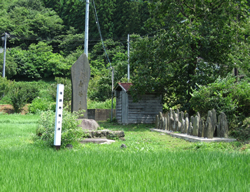 田の中に建つ後藤寿庵の墓を示す碑と墓石群